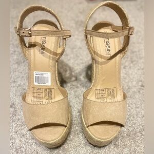 Wedge platforms with rope-bound heel. Straps around ankle w/ gold colored clasp
